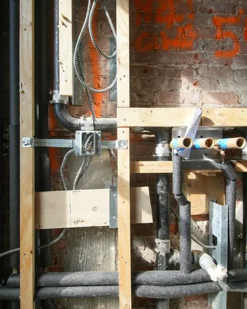 Open wall: new pipes and wiring inside the bathroom wall, before it is closed up